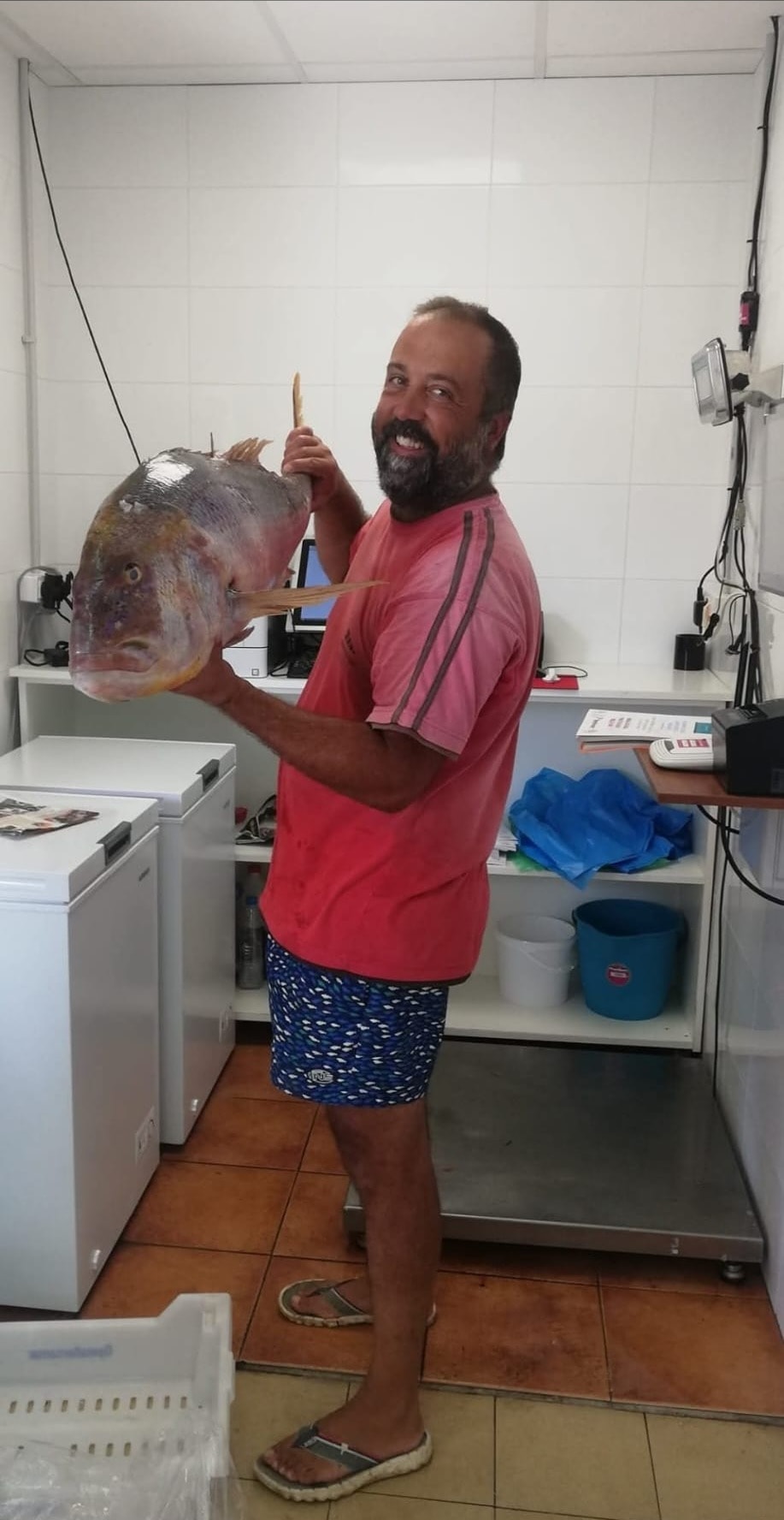N'Andreu Gil amb un peix acabat de pescar a la llotja de Cala Bona